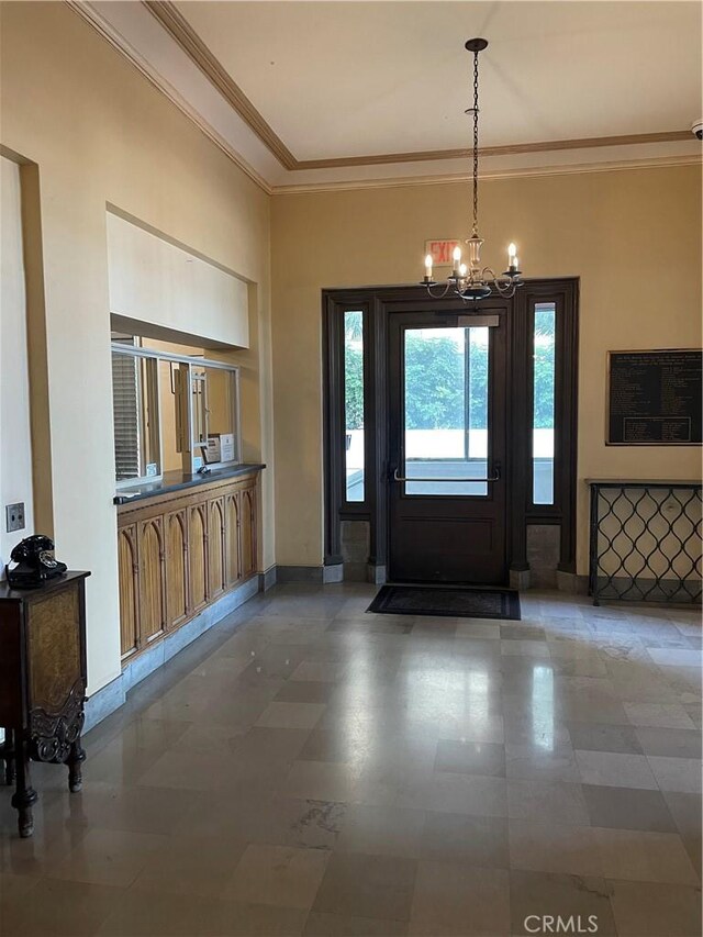 foyer with baseboards, a notable chandelier, and crown molding