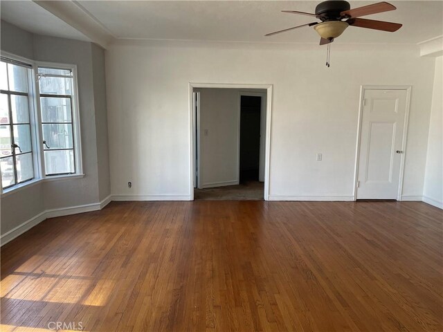 unfurnished room featuring baseboards, a ceiling fan, and wood finished floors