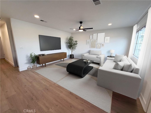 living room featuring ceiling fan and light wood-type flooring