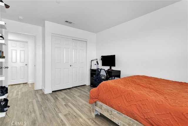 bedroom with light hardwood / wood-style flooring and a closet