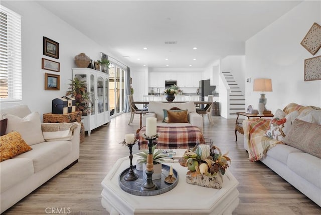 living room with light hardwood / wood-style floors and sink