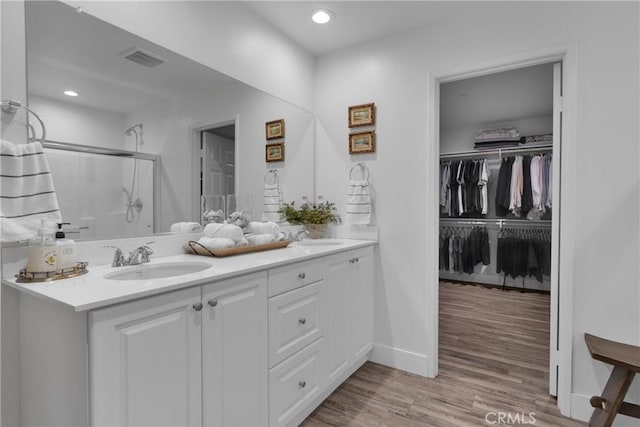 bathroom with vanity, an enclosed shower, and hardwood / wood-style flooring