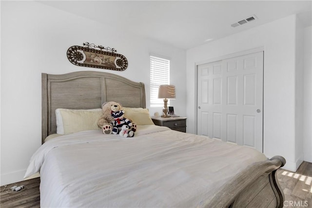 bedroom featuring dark hardwood / wood-style flooring and a closet