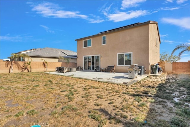 back of property with a yard and a patio