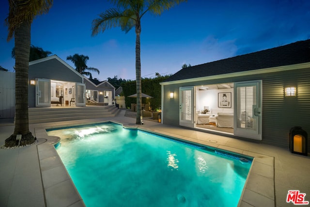 pool at dusk featuring a patio area