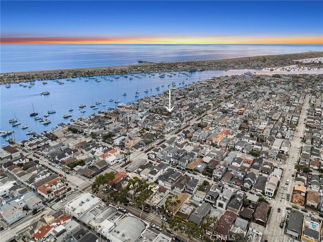 aerial view at dusk featuring a water view