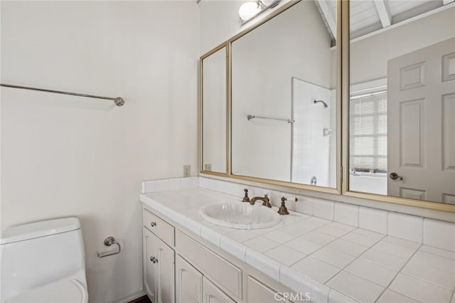 bathroom featuring toilet, walk in shower, and vanity