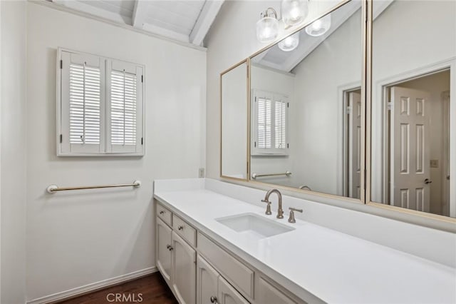 bathroom with hardwood / wood-style flooring, vanity, and lofted ceiling with beams