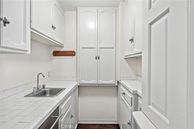 kitchen featuring white cabinetry, tile counters, and sink