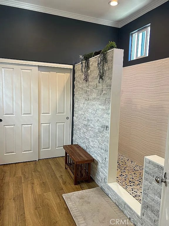 bathroom featuring wood-type flooring and ornamental molding