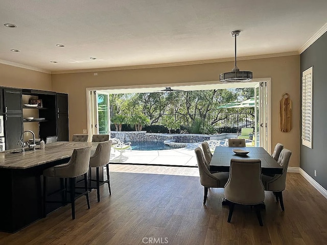 dining area featuring dark hardwood / wood-style floors, ornamental molding, and sink