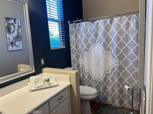 bathroom with vanity, toilet, and wood-type flooring