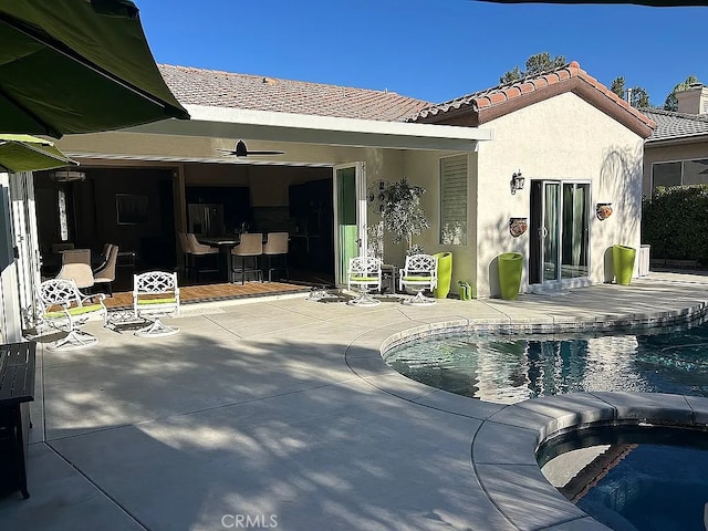 view of pool featuring ceiling fan, an in ground hot tub, and a patio