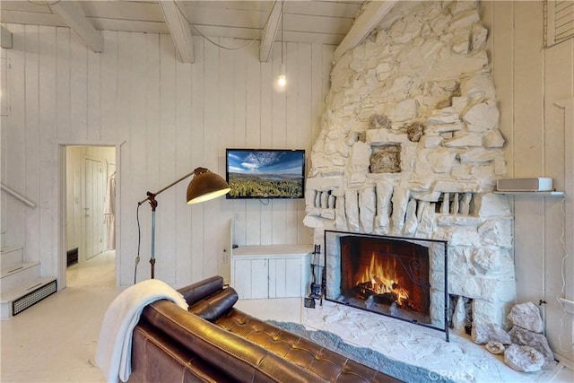 interior space with a fireplace, beam ceiling, wooden ceiling, and wooden walls