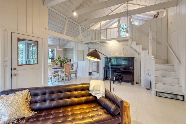 living room featuring wooden walls, beamed ceiling, and high vaulted ceiling