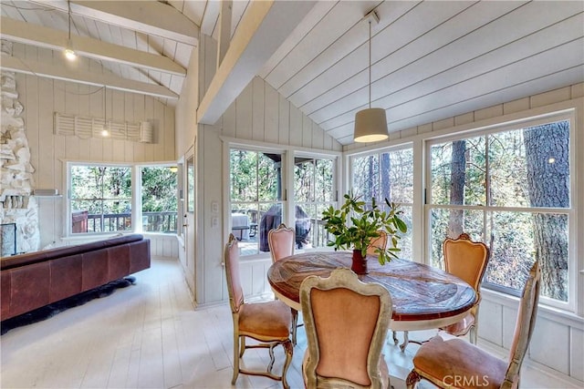 sunroom / solarium with lofted ceiling with beams and a healthy amount of sunlight