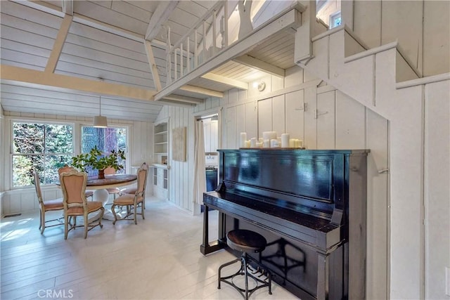 misc room with beamed ceiling, light hardwood / wood-style floors, wood walls, and wooden ceiling