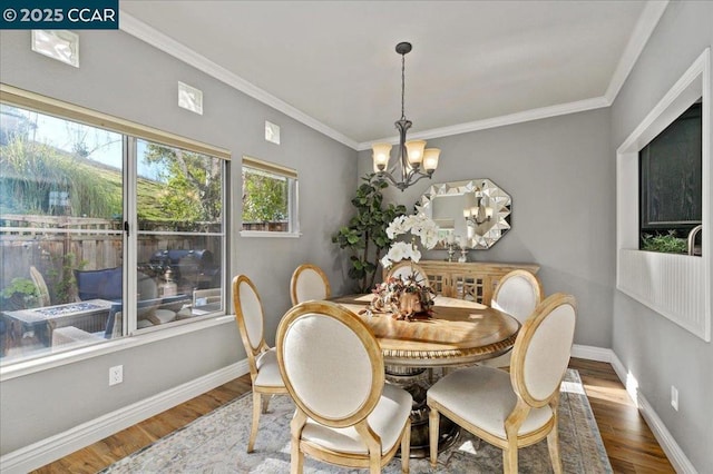 dining space featuring a notable chandelier, hardwood / wood-style flooring, and crown molding