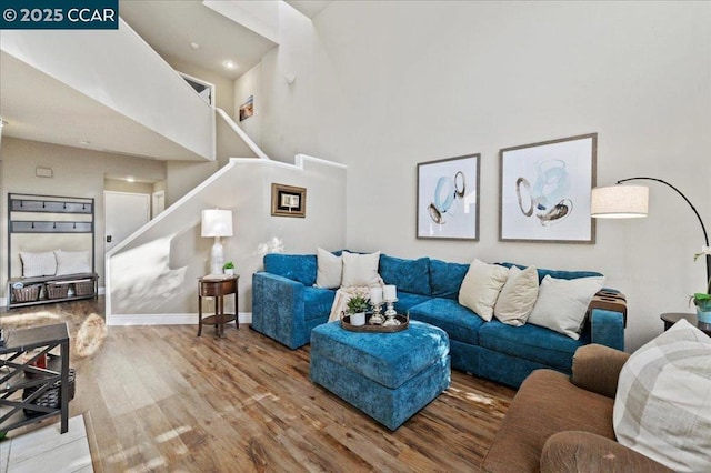 living room featuring hardwood / wood-style flooring and a towering ceiling