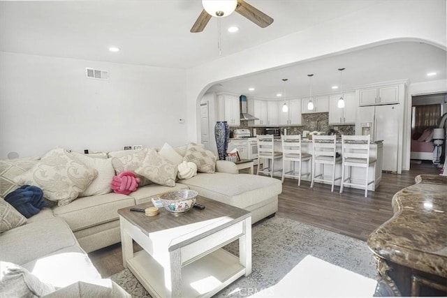 living room featuring ceiling fan and dark hardwood / wood-style floors