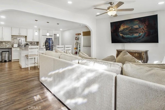 living room with ceiling fan, sink, and dark hardwood / wood-style floors