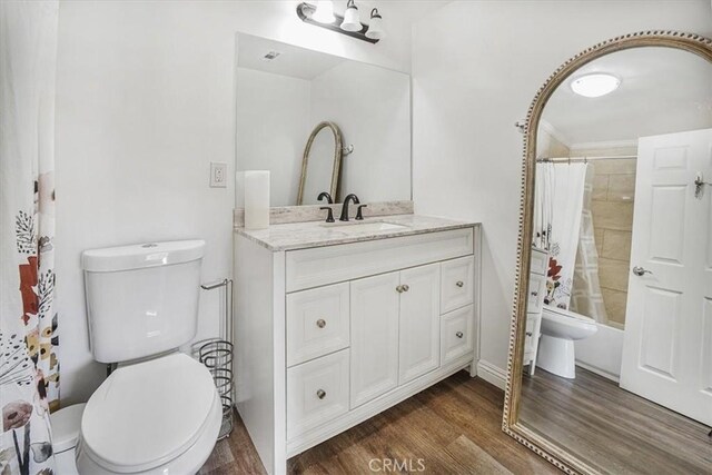 bathroom with hardwood / wood-style flooring, toilet, vanity, and ornamental molding