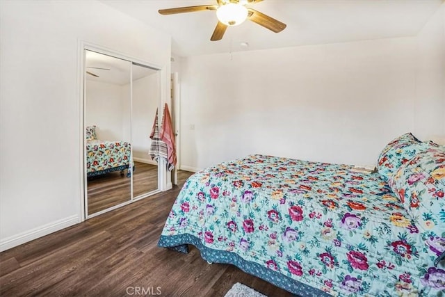 bedroom with a closet, dark hardwood / wood-style floors, and ceiling fan