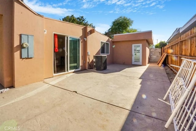 rear view of house featuring central AC unit and a patio