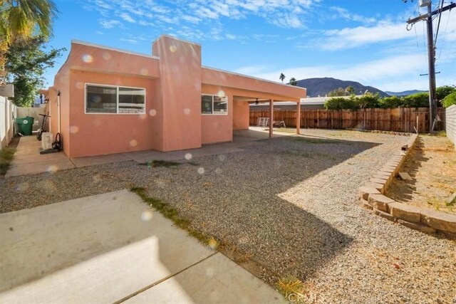 rear view of property featuring a mountain view and a patio area