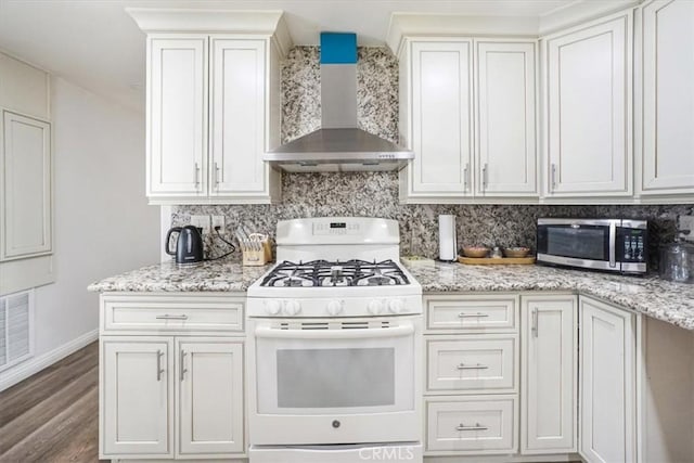 kitchen with wall chimney exhaust hood, white cabinetry, wood-type flooring, backsplash, and white gas stove