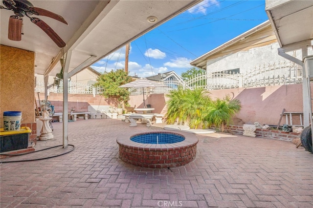 view of patio featuring ceiling fan and an outdoor fire pit