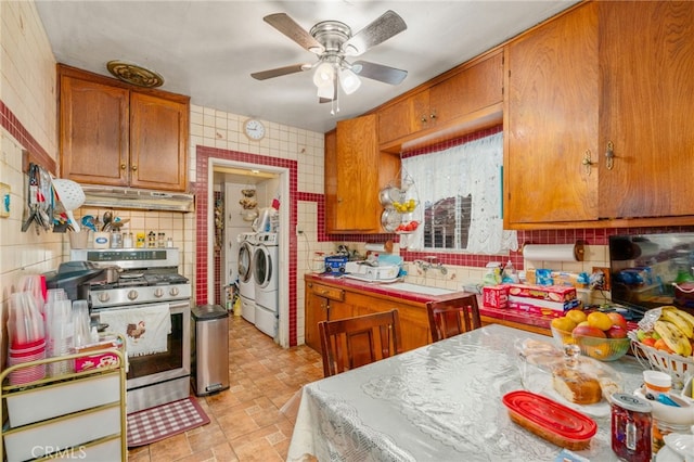 kitchen with sink, decorative backsplash, ceiling fan, stainless steel range with gas stovetop, and washing machine and clothes dryer