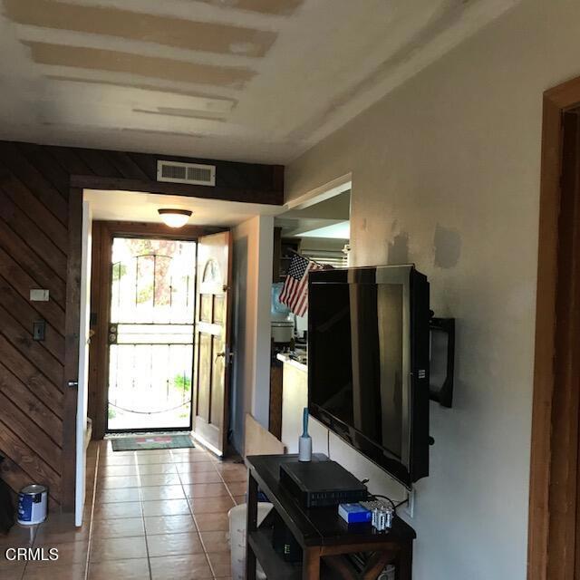 tiled foyer entrance with wood walls