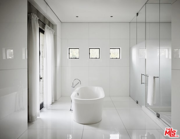 bathroom featuring tile patterned floors, tile walls, and independent shower and bath