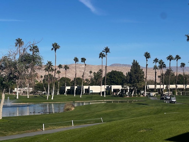 view of community with a lawn and a water and mountain view