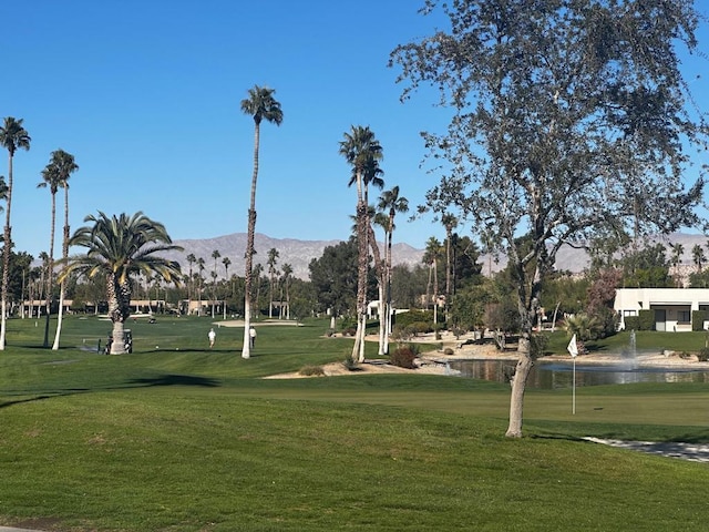 view of community featuring a lawn and a water and mountain view