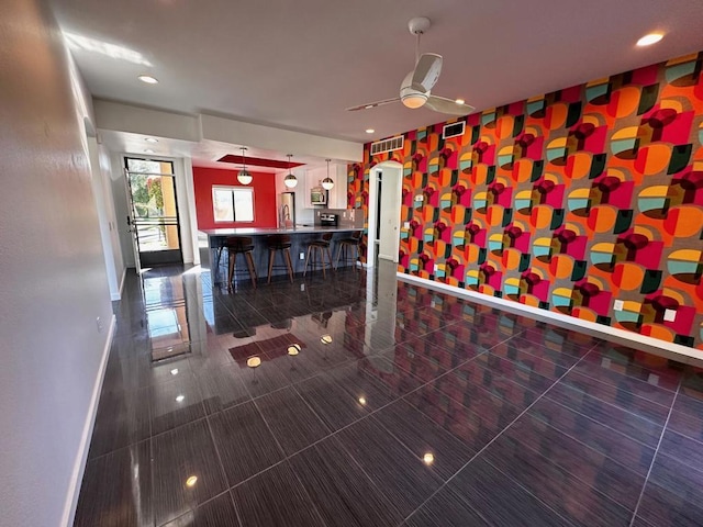 interior space with ceiling fan and dark tile patterned floors