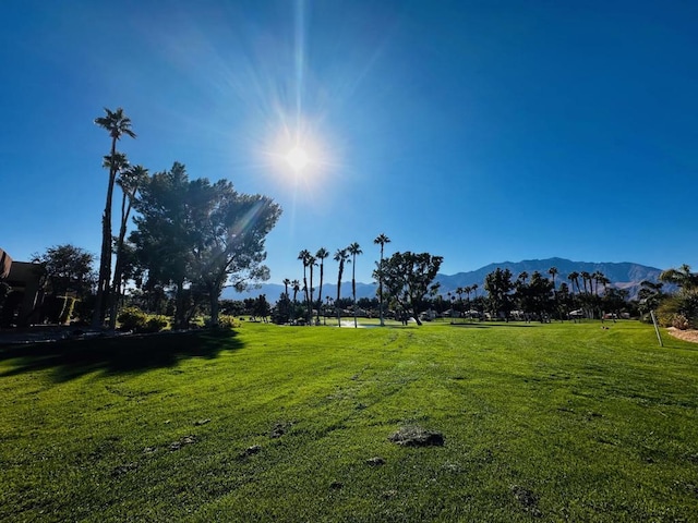 view of home's community with a mountain view and a lawn