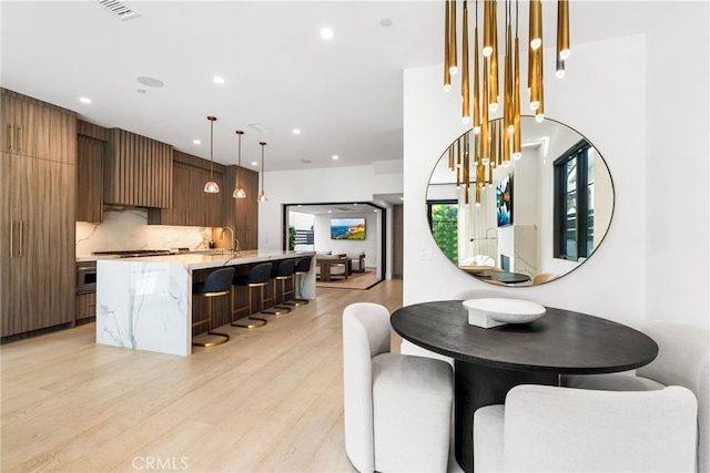 dining space featuring light hardwood / wood-style floors and sink