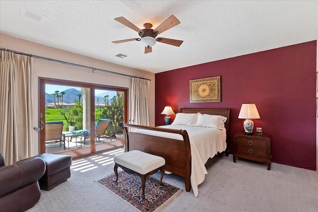 carpeted bedroom featuring ceiling fan, access to outside, and a textured ceiling