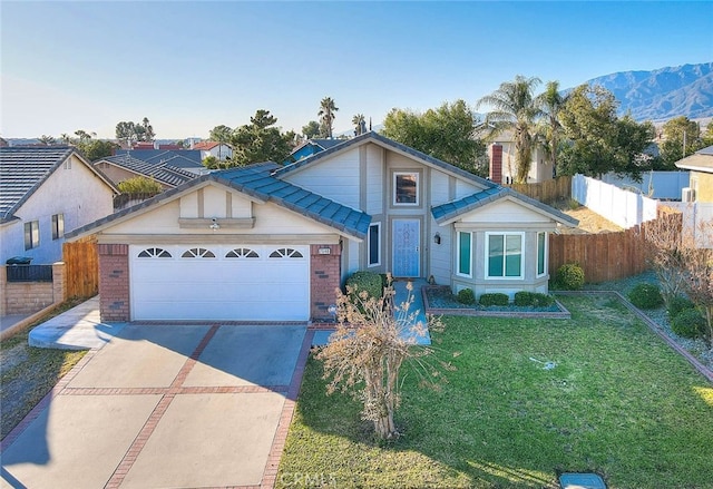 view of front of property with a front lawn, a garage, and a mountain view