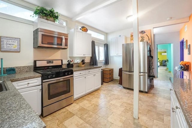 kitchen featuring beamed ceiling, appliances with stainless steel finishes, and white cabinetry