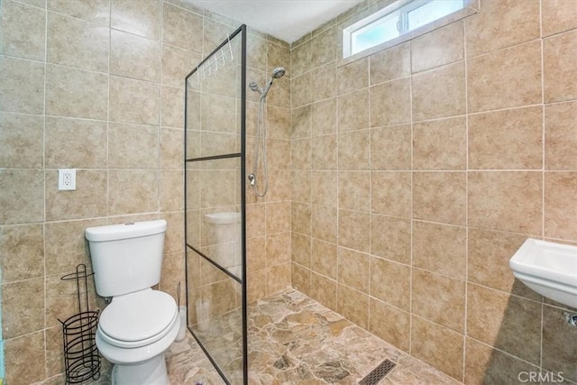 bathroom with toilet and tiled shower