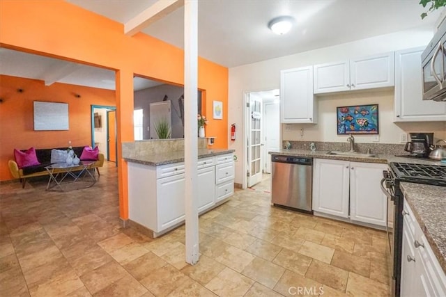 kitchen featuring white cabinets, appliances with stainless steel finishes, beam ceiling, and sink