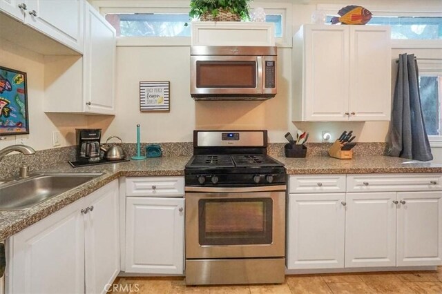 kitchen with white cabinets, sink, stainless steel appliances, and a wealth of natural light