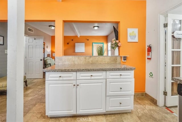 kitchen with white cabinets and beamed ceiling