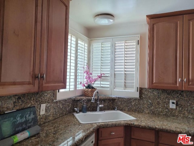 kitchen with stone countertops, tasteful backsplash, and sink