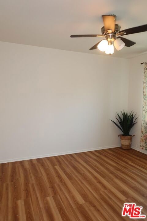 unfurnished room with ceiling fan and wood-type flooring