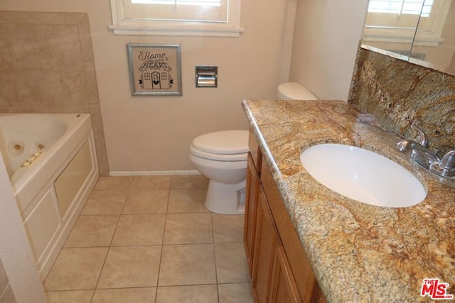 bathroom with tile patterned floors, vanity, toilet, and a bath