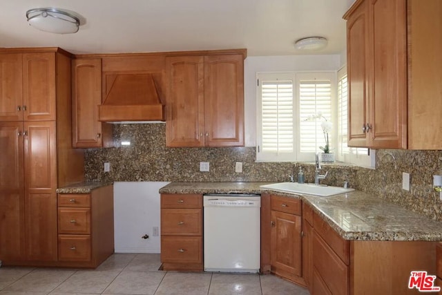 kitchen with dishwasher, custom exhaust hood, sink, decorative backsplash, and light tile patterned floors